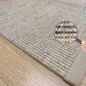 the corner of the sisal rug, with beige border and brown-beige mat color