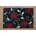 rug Color: black with a pattern of large red roses with gray leaves.