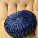 blue round pillow with pleats with velvet texture, on a black background