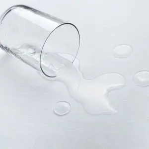 waterproof mattress pad, glass of spilling water on the pad