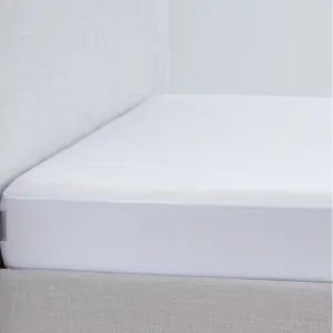 Waterproof white cotton mattress cover La Luna ACQUA on a bed dressed in grey