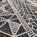 summer rug with black wicker weave and white geometric patterns such as diamonds, triangles and squares