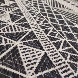 summer rug with black wicker weave and white geometric patterns such as diamonds, triangles and squares