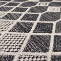 summer rug with black and off-white wicker weave in different patterns of diamonds and lines
