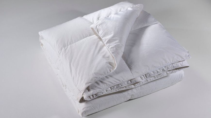 Διπλωμένο λευκο πουπουλένιο πάπλωμα